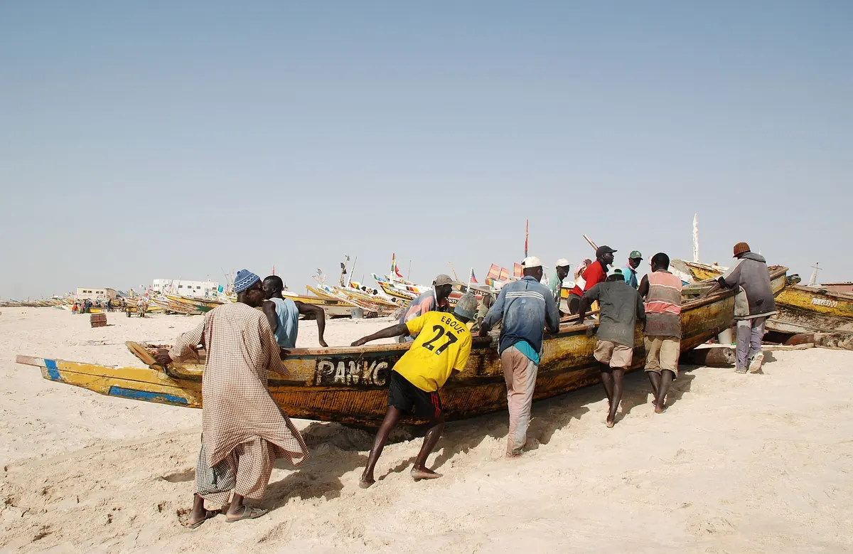 صيادون يسحبون زورقاً في ميناء الصيد التقليدي بنواكشوط