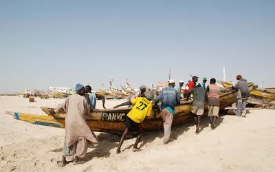 صيادون يسحبون زورقاً في ميناء الصيد التقليدي بنواكشوط